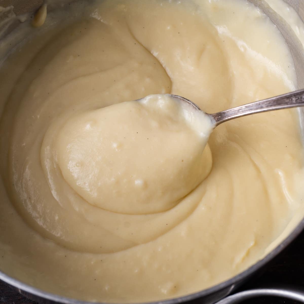 a spoon in a saucepan with pudding