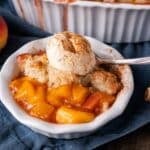 peach cobbler in a bowl with ice cream