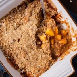 peach crisp in a dish with a spoon